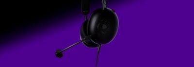 Audífonos tipo diadema negros con micrófono sobre un fondo morado y negro