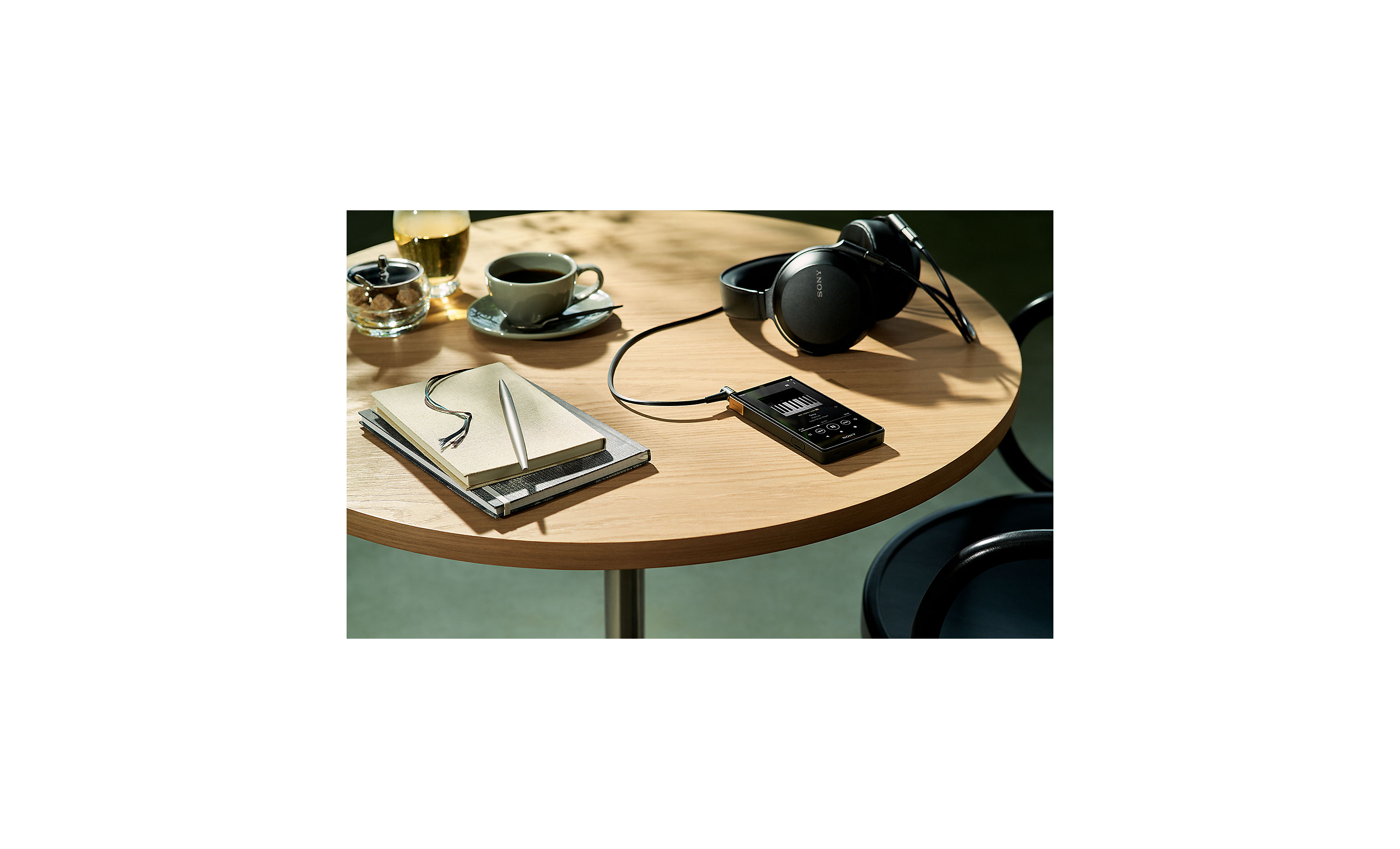 Hình ảnh NW-ZX707 nằm trên bàn cùng với tai nghe của Sony.