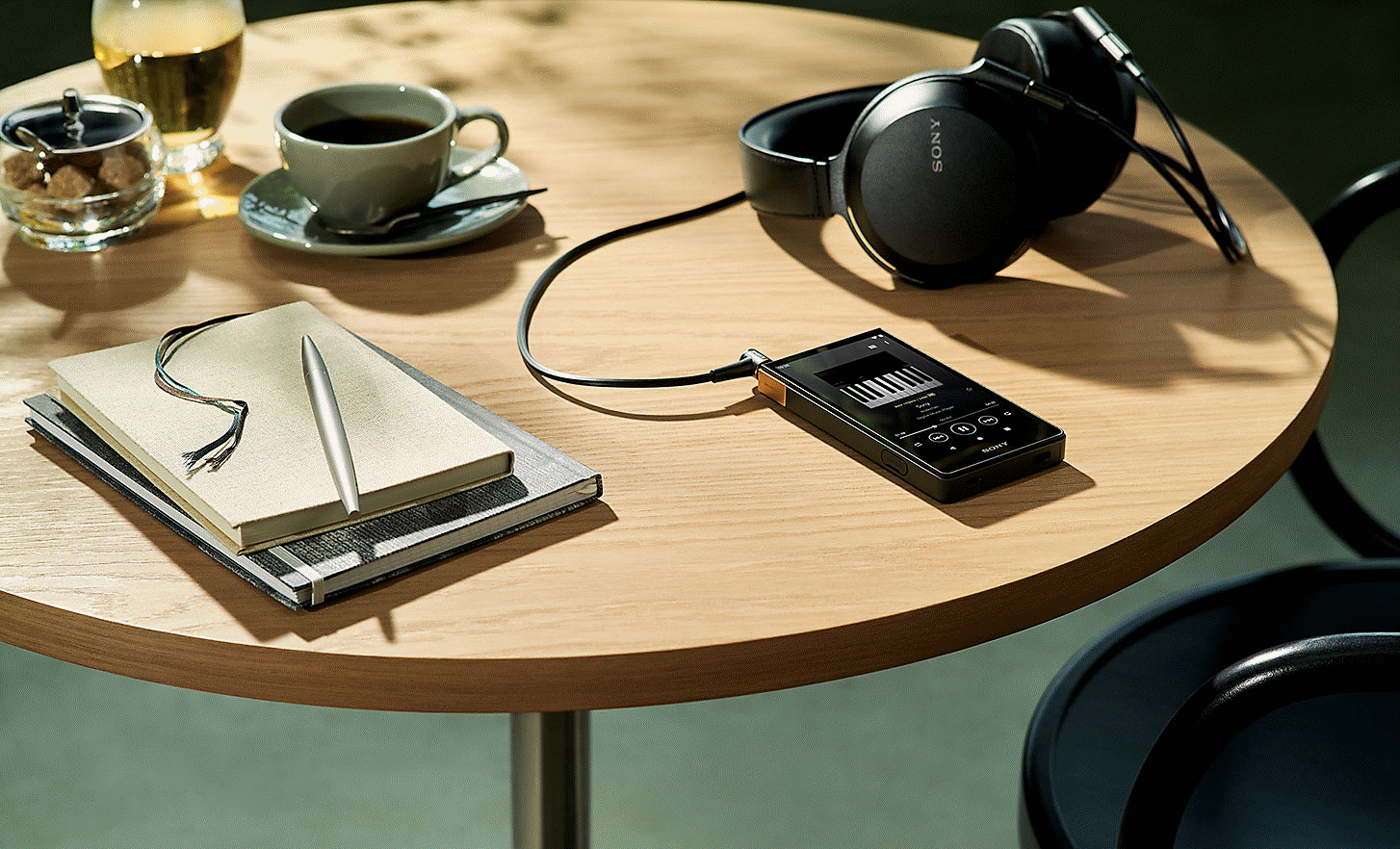 An image of the NW-ZX707 laying on a table, with Sony headphones.