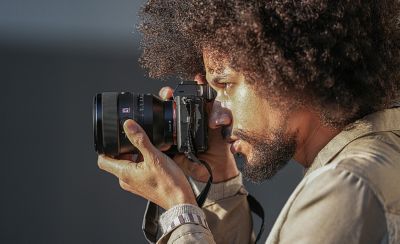 Image of a person holding a camera with the FE 50mm F1.2 GM lens attached