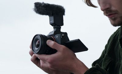 Image of a man recording a video clip while operating the E PZ 10-20mm F4 G's zoom lever