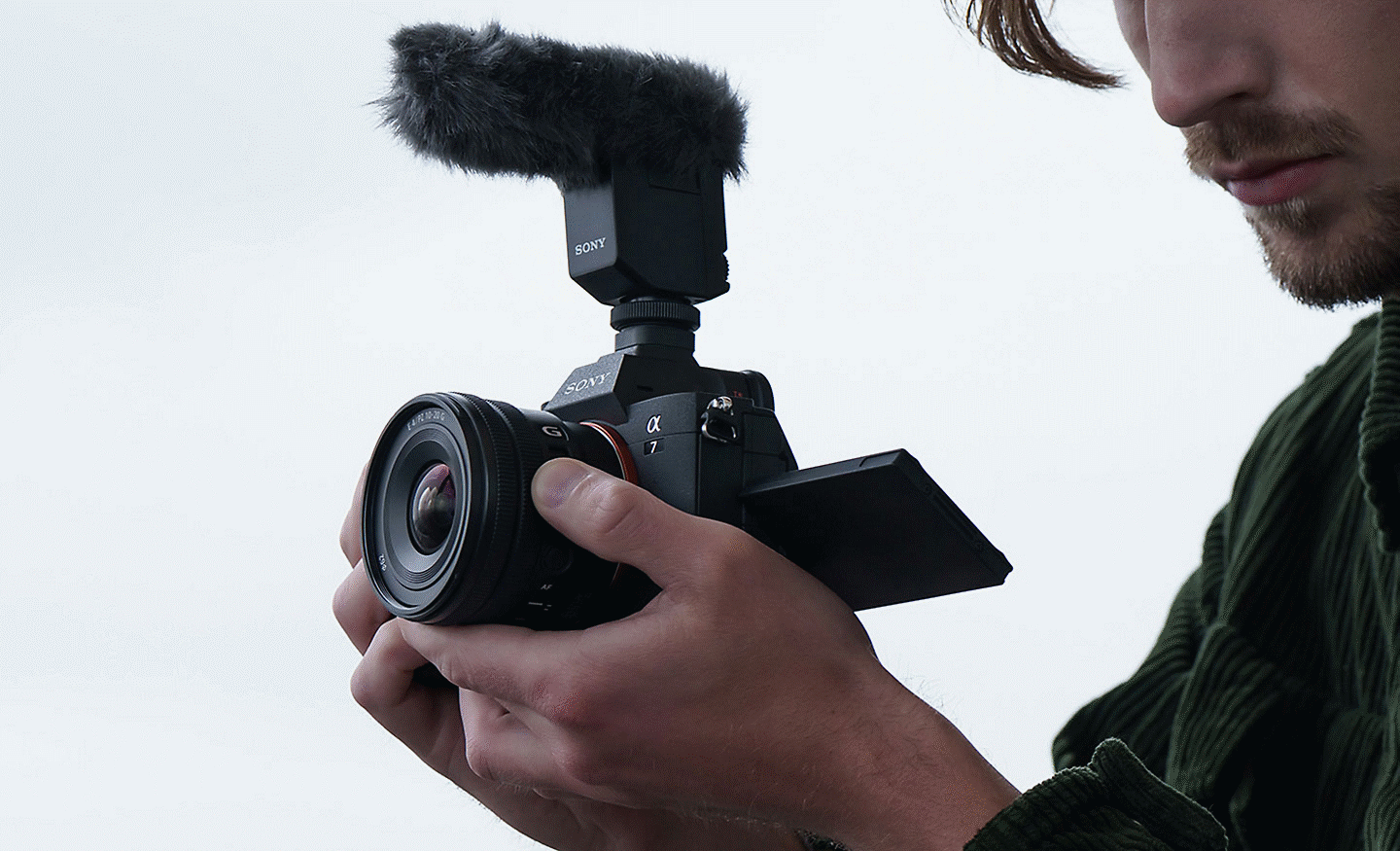 Image of a man recording a video clip while operating the E PZ 10-20mm F4 G's zoom lever