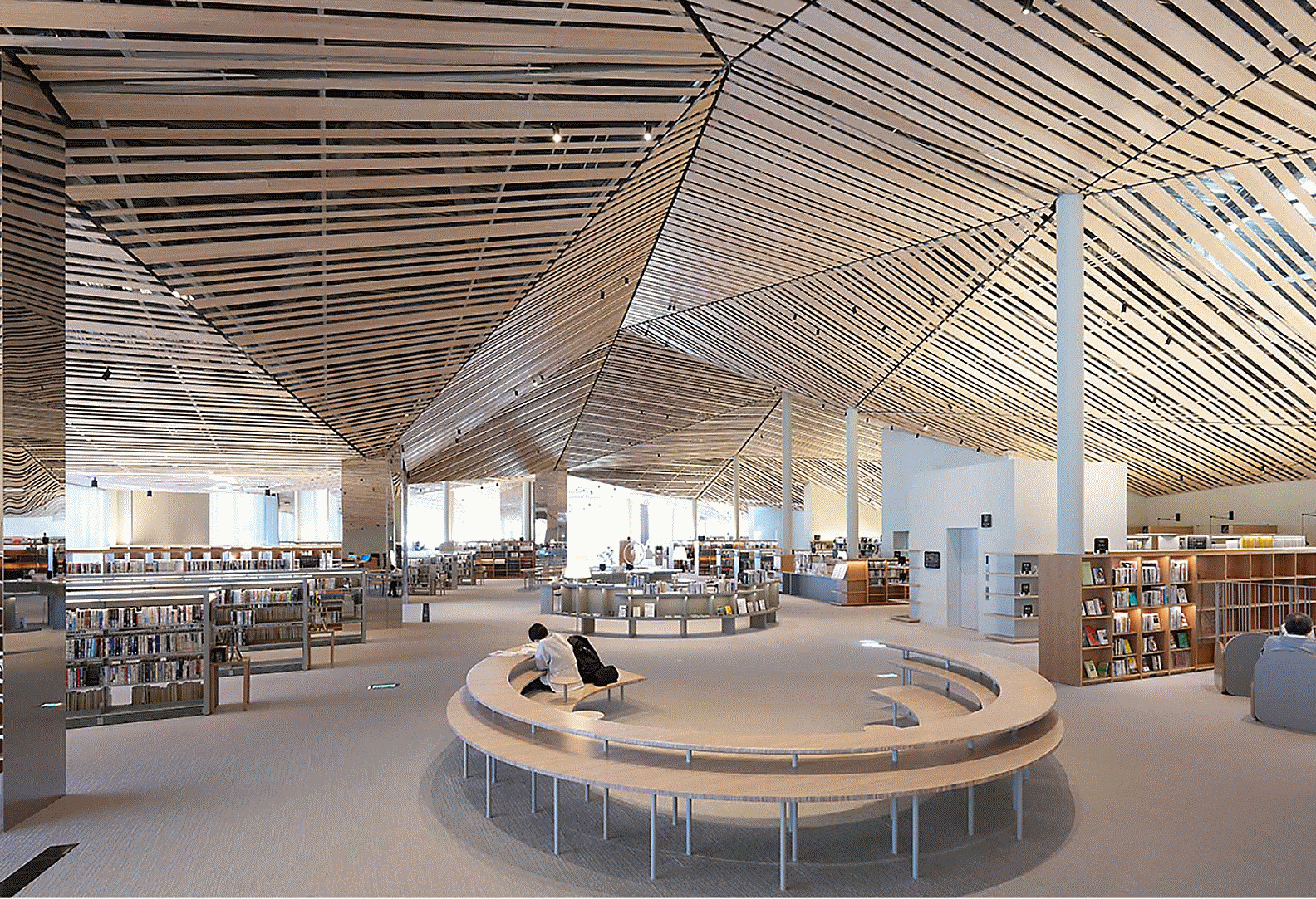 Billede af interiøret i et stort bibliotek med et kunstfærdigt design med mange lige træplanker i loftet med flot opløsning på hele skærmen