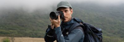 Situační snímek muže držícího fotoaparát s horou v pozadí