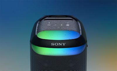 Close up of the top of the SRS-XV800 speaker with blue and green ambient lighting and water drops on the top