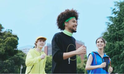 Three friends walking, one of whom is wearing LinkBuds Open earbuds.