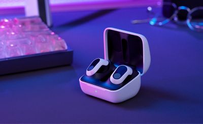 The INZONE Buds in their charging case sitting on a desk with a keyboard