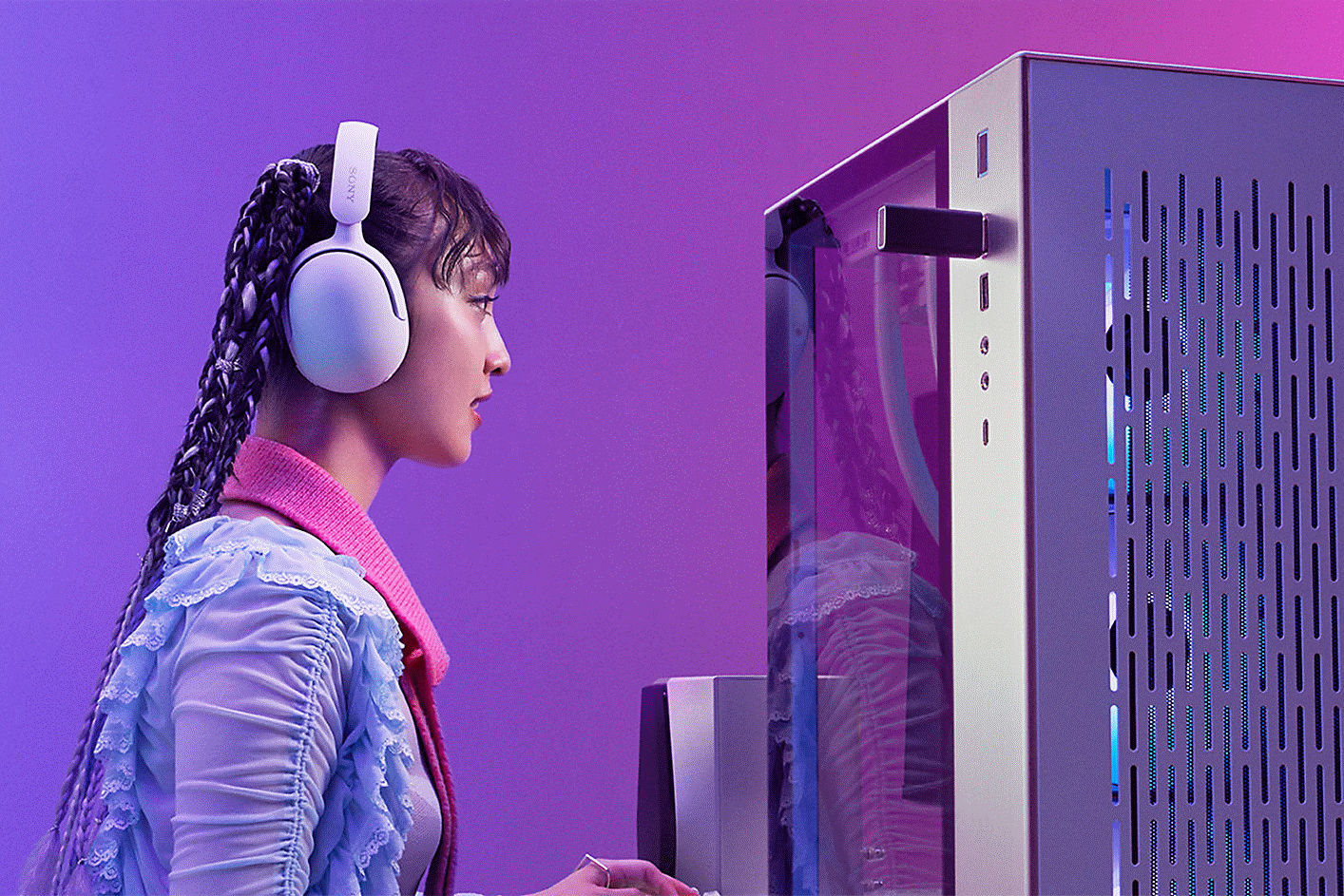 Una gamer sentada frente a la computadora con unos audífonos INZONE H5