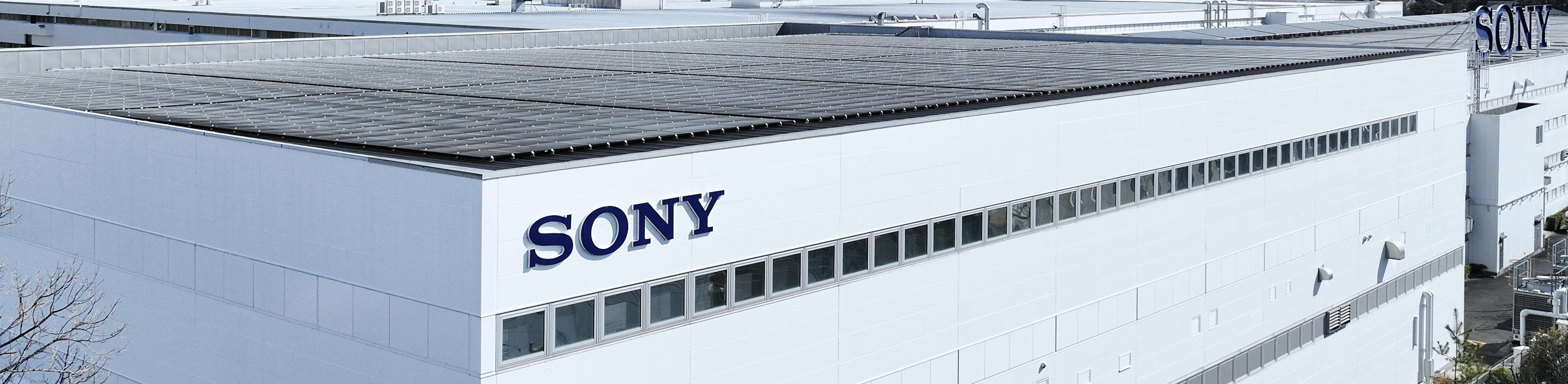 صورة فوتوغرافية تُظهر سطح مصنع مع لوح شمسي وشعار "سوني"