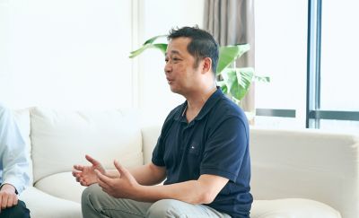 M. Hatanaka assis sur le canapé en train de parler