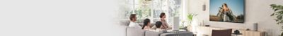 An image of a family of four watching TV while relaxing on the sofa.