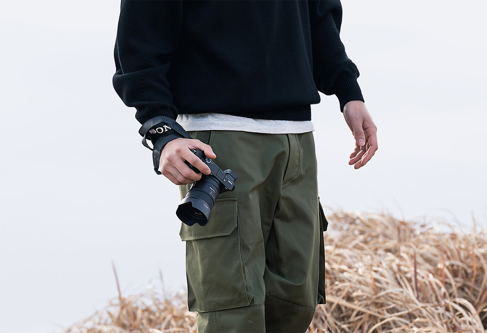 Slika muškarca koji nosi fotoaparat u ruci