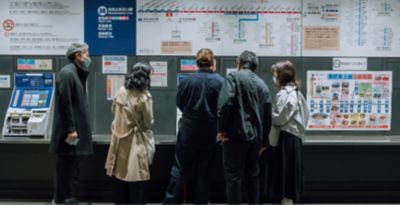 The lead user is buying a ticket at a ticket vending machine