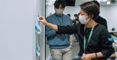 An employee is posting a note on a whiteboard