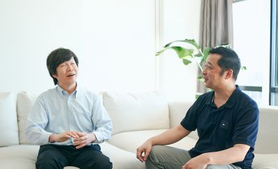 M. Suzuki et M. Hatanaka discutent assis sur le canapé.