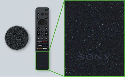 An image with a remote control and pellets aligned. The remote control is partially enlarged to show its surface texture more clearly.