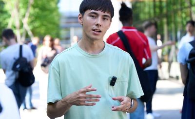 Imagen en la que se muestra a un usuario con un micrófono puesto hablando en un espacio público abarrotado