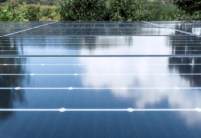 Photograph showing factory rooftop covered withof solar panels