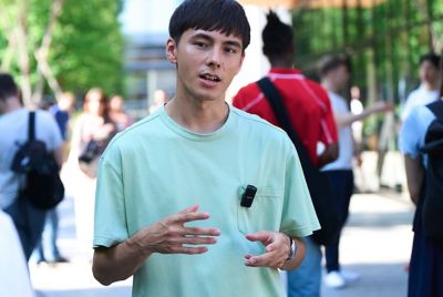 Imagen en la que se muestra a un usuario con un micrófono puesto hablando en un espacio público abarrotado