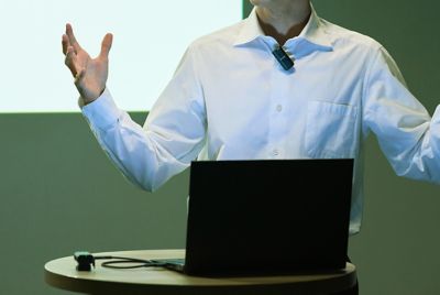 Foto de un hombre que realiza una presentación con un micrófono en la ropa