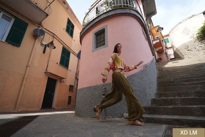în timp ce urcă scări relaxat, cu obiectivul FE 16–35 mm F2.8 GM montat și cureaua Sony înfășurată în jurul încheieturii