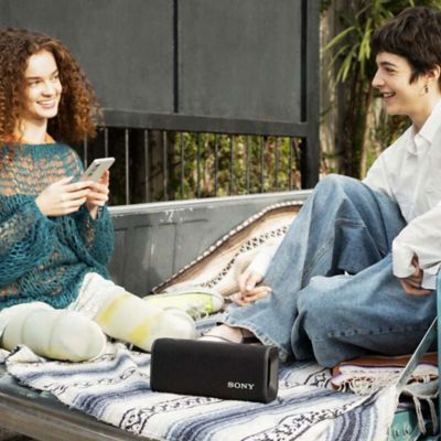 Dos mujeres están sentadas en la parte trasera de un automóvil con ULT FIELD 3.