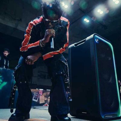 Un hombre haciendo una presentación en un escenario con el ULT TOWER MAX y ULTMIC1 en un evento en vivo.