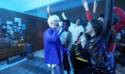 Imagen de personas cantando y bailando alegremente usando ULT TOWER 9 y ULTMIC1 con amigos en un lugar de fiesta en el interior