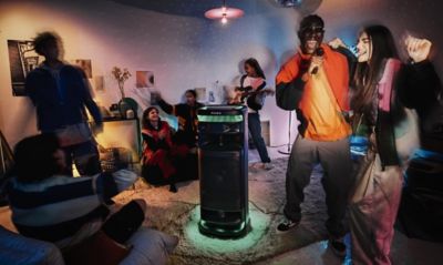 Image of ULT TOWER 10 party speaker and group of young people danging in the living room