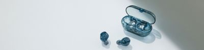 El estuche de carga azul transparente se muestra junto al par de audífonos azules transparentes