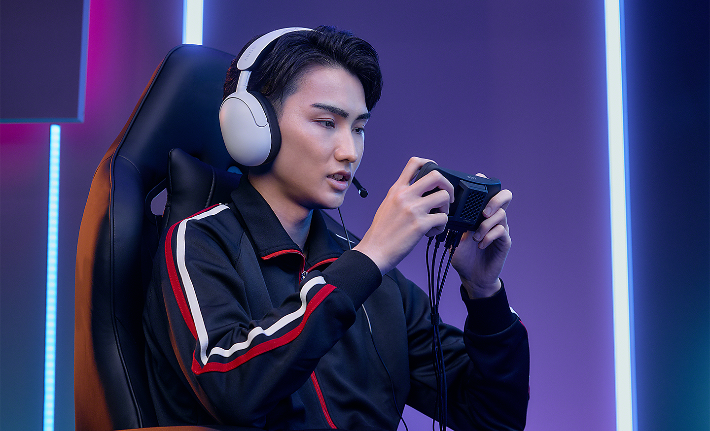 Pro gamer wearing a headset, concentrating hard as he plays on Xperia Stream for Xperia 1 IV 